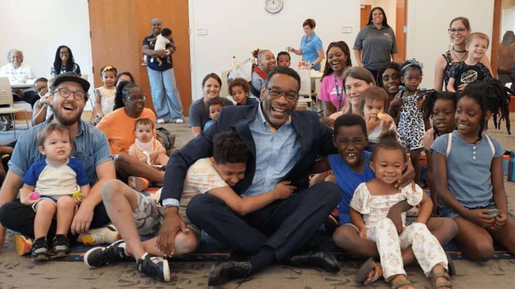 Kids sitting with United Way CEO, Milton Little, in an early education program funded by united way donations.